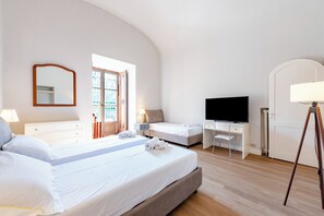 Ein Schlafzimmer mit einem Bett, einem Schreibtisch, einem Fernseher und einer Lampe.