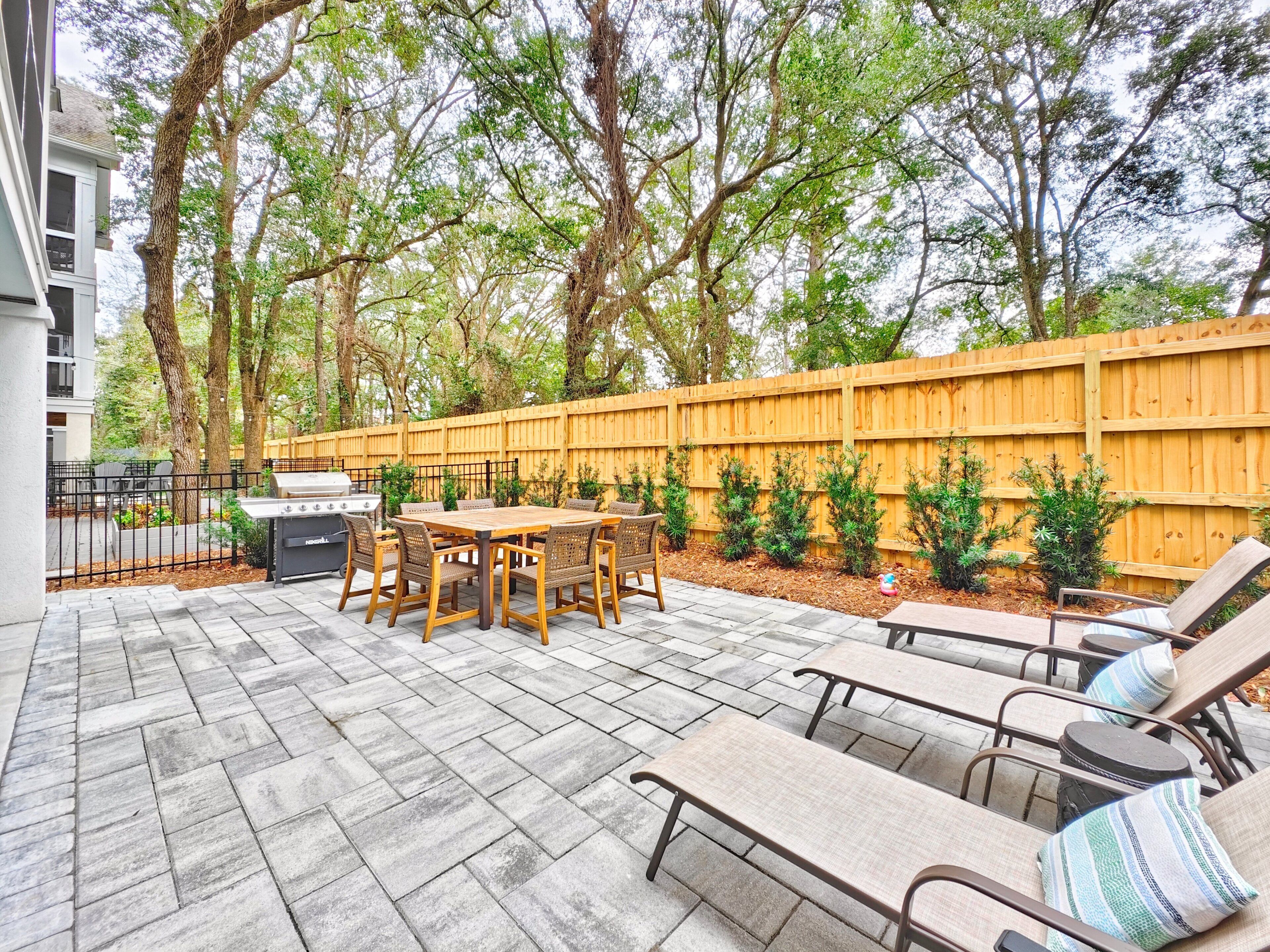 A patio with a grill, a table, and chairs.