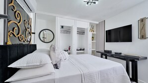 Une chambre d’hôtel moderne dotée d’un grand lit, d’une télévision à écran plat, d’un bureau et d’une armoire.