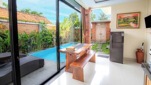 Eine moderne Küche mit Pool, Holzmöbeln und einem großen Fenster.