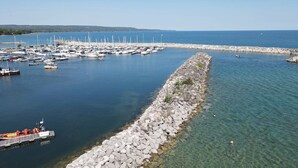 A marina with boats docked and a rocky breakwater.