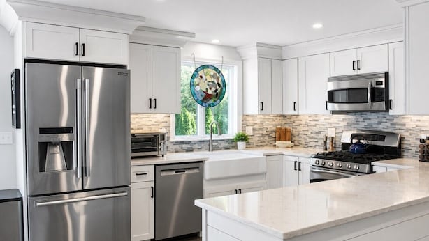 A modern kitchen with stainless steel appliances, white cabinetry, and a large island. - Classic Renovated Cape Cod Getaway (Falmouth)