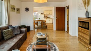 Uma sala de estar moderna com sofá, mesa de centro e área de jantar.