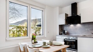A modern kitchen with a large window, a built-in oven, and a view of a vineyard. - Holiday Apartment 'Rieslingglück' with Wi-Fi (Trittenheim)