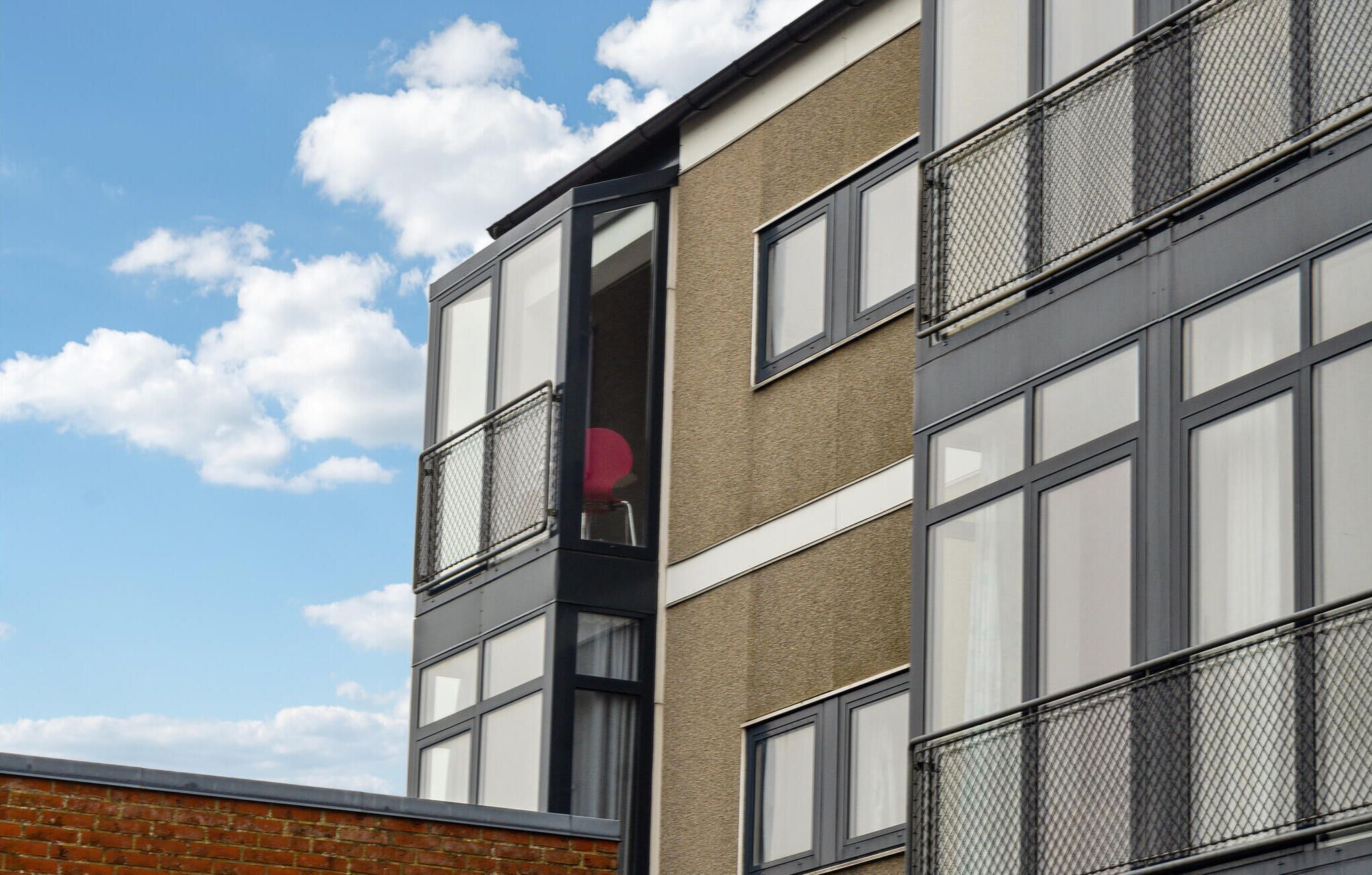 A multi-story building with large windows and a brick facade.