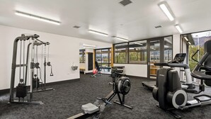 Ein Fitnessstudio mit Cardiogeräten, Krafttrainingsgeräten und großen Fenstern mit Blick.