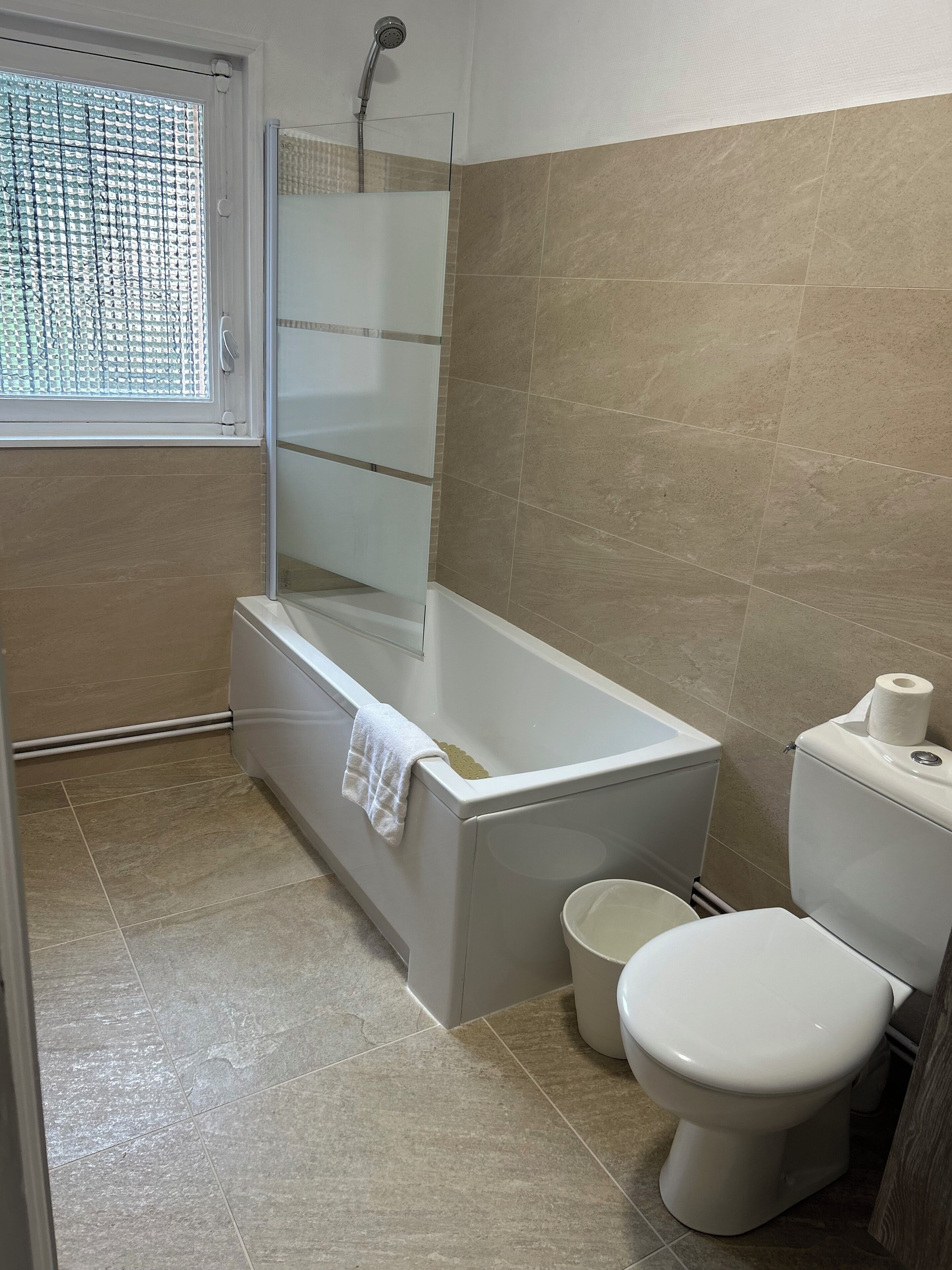 Un baño moderno con ducha de vidrio, bañera, inodoro y bidé.