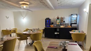 A dining area with yellow chairs and a wooden table, equipped with a coffee machine and a refrigerator. - Comme chez soi (Jas)