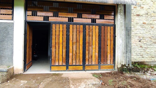 A building entrance with a wooden gate and a stone wall. - Hotel O Wisma Alam Syariah Near PLN GARDU INDUK MAMUJU (Mamuju)