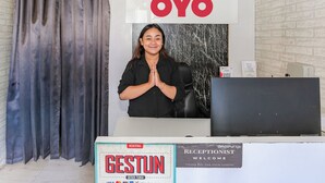 A reception desk with a sign that reads "OYO" and another sign that says "GESTUN" with a welcome message. - Capital O 93371 Pelangi Residence 5  (South Tangerang)