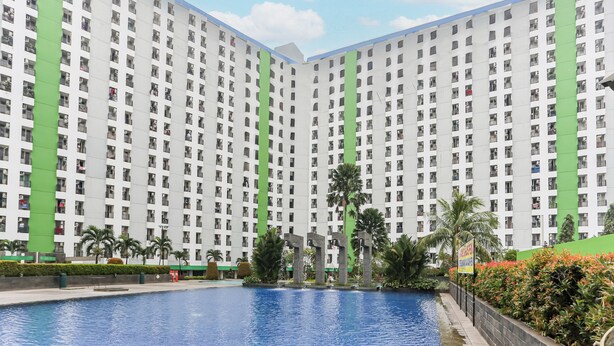 A high-rise residential building with a swimming pool and palm trees. - Capital O 93371 Pelangi Residence 5  (South Tangerang)