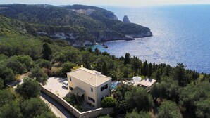 Une propriété située sur la côte, comprenant un bâtiment d’un seul étage, une piscine et une vue sur la mer et les falaises.