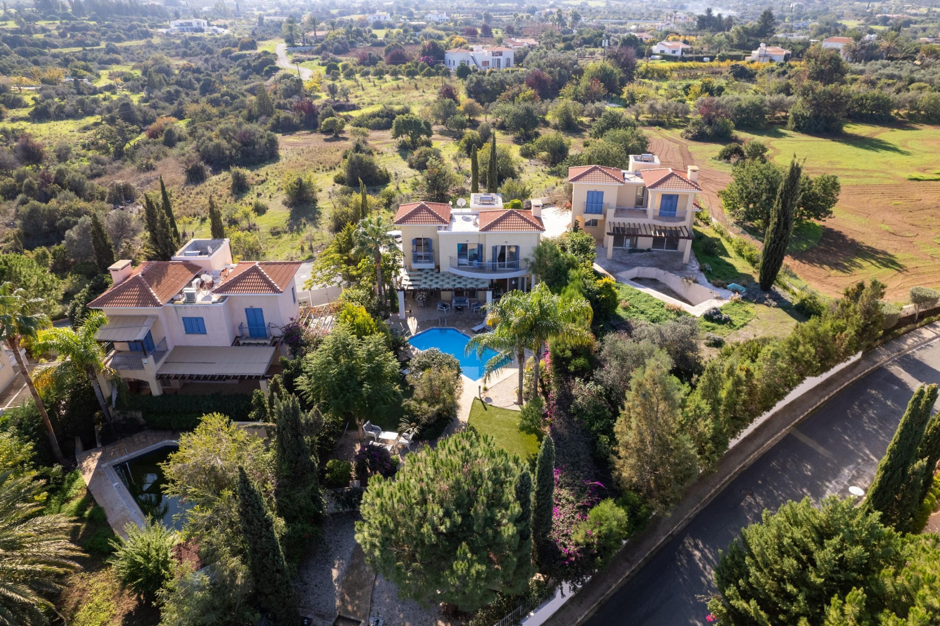 A large estate with multiple houses, a swimming pool, and lush greenery.