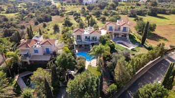 A large estate with multiple houses, a swimming pool, and lush greenery.