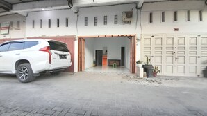 Un VUS blanc est garé dans un garage dont la porte est rouge, et une autre porte, blanche, est dotée de plusieurs serrures.