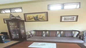 Un salon comprenant un canapé, une table basse, un meuble et deux tableaux encadrés accrochés au mur.