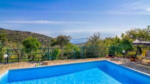 A swimming pool with a view of a hilly landscape. - Villa Melissa Paxos in Paxi (Paxos)