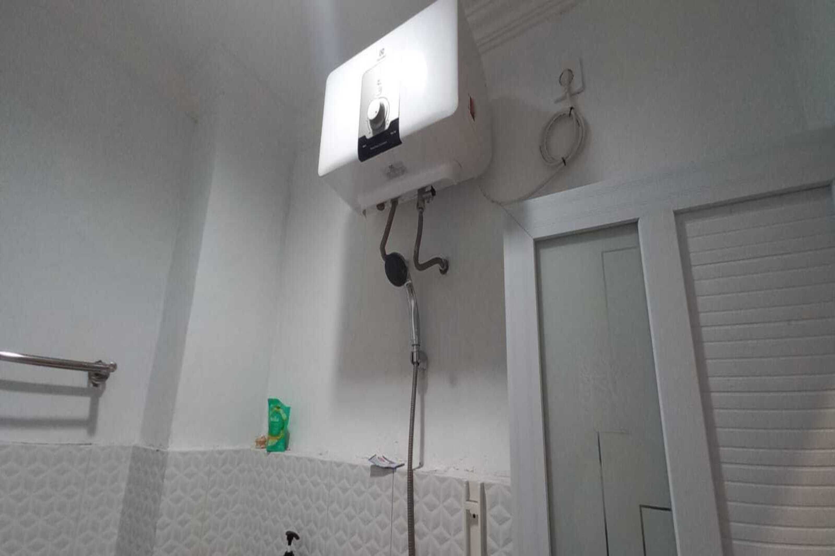 A bathroom with a white toilet, a shower, and a towel rack.