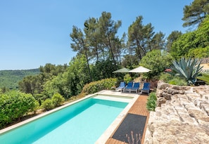 A swimming pool with lounge chairs and a view of trees and hills. - Mas des Violettes – Luxury vacation villa in the Alpes-Maritimes (Tourretes sur Loup)