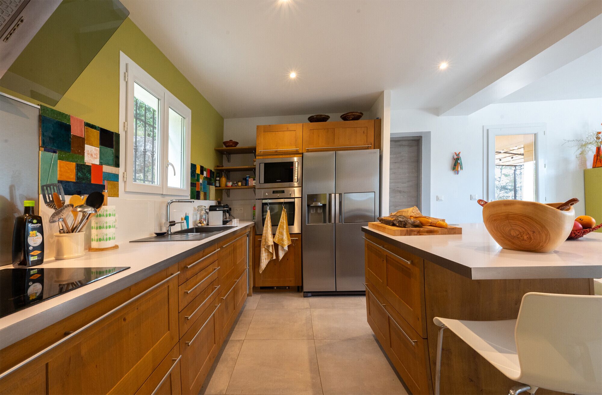 Una cocina moderna con armarios de madera, electrodomésticos de acero inoxidable y una isla grande.