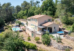 A two-story house with a swimming pool, outdoor seating, and a tennis court. - Mas des Violettes – Luxury vacation villa in the Alpes-Maritimes (Tourretes sur Loup)