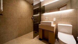 Ein modernes Badezimmer mit großem Spiegel, Waschbecken und Toilette.