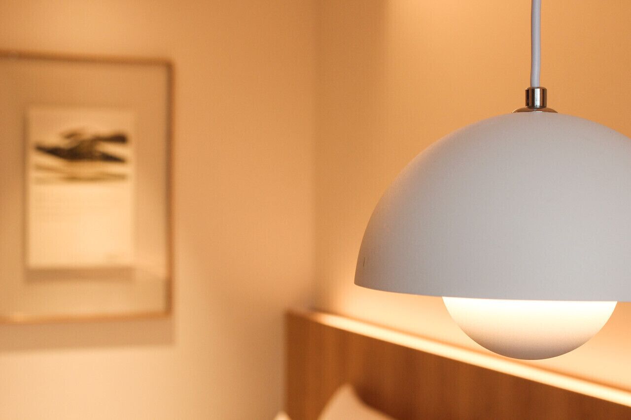 A pendant light fixture with a white shade hanging from a ceiling.