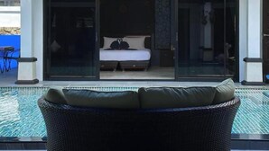 Une chambre avec un lit, une porte vitrée donnant sur un balcon et une vue sur une piscine.