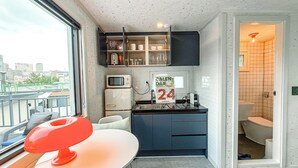 A compact kitchen with a microwave, a refrigerator, and a calendar on the wall. - Steps away from DDP, Airport Bus, DongDaeMun Shopping Malls [Timeless Rooftop] (Seoul)