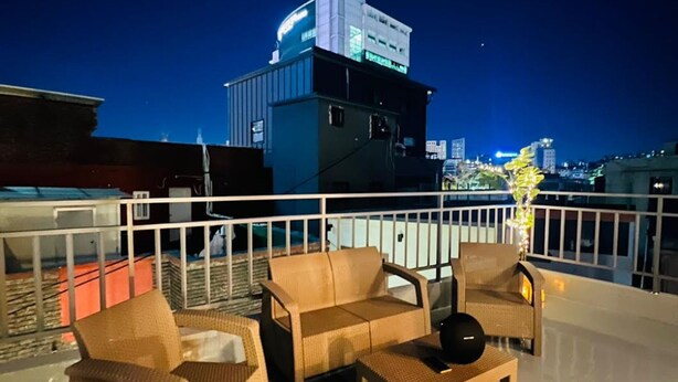 A rooftop terrace with wicker furniture, a small table, and a speaker. - Steps away from DDP, Airport Bus, DongDaeMun Shopping Malls [Timeless Rooftop] (Seoul)