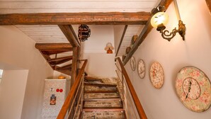 A wooden staircase with a rustic design, a refrigerator, and decorative wall clocks. - Penelope Stone House (Corfu)