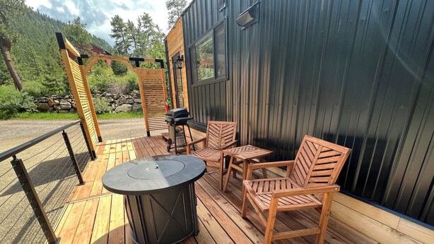 A deck with a grill, chairs, and a table. - Chipmunk Tiny Home at The Woolly Bugger Inn (Estes Park)