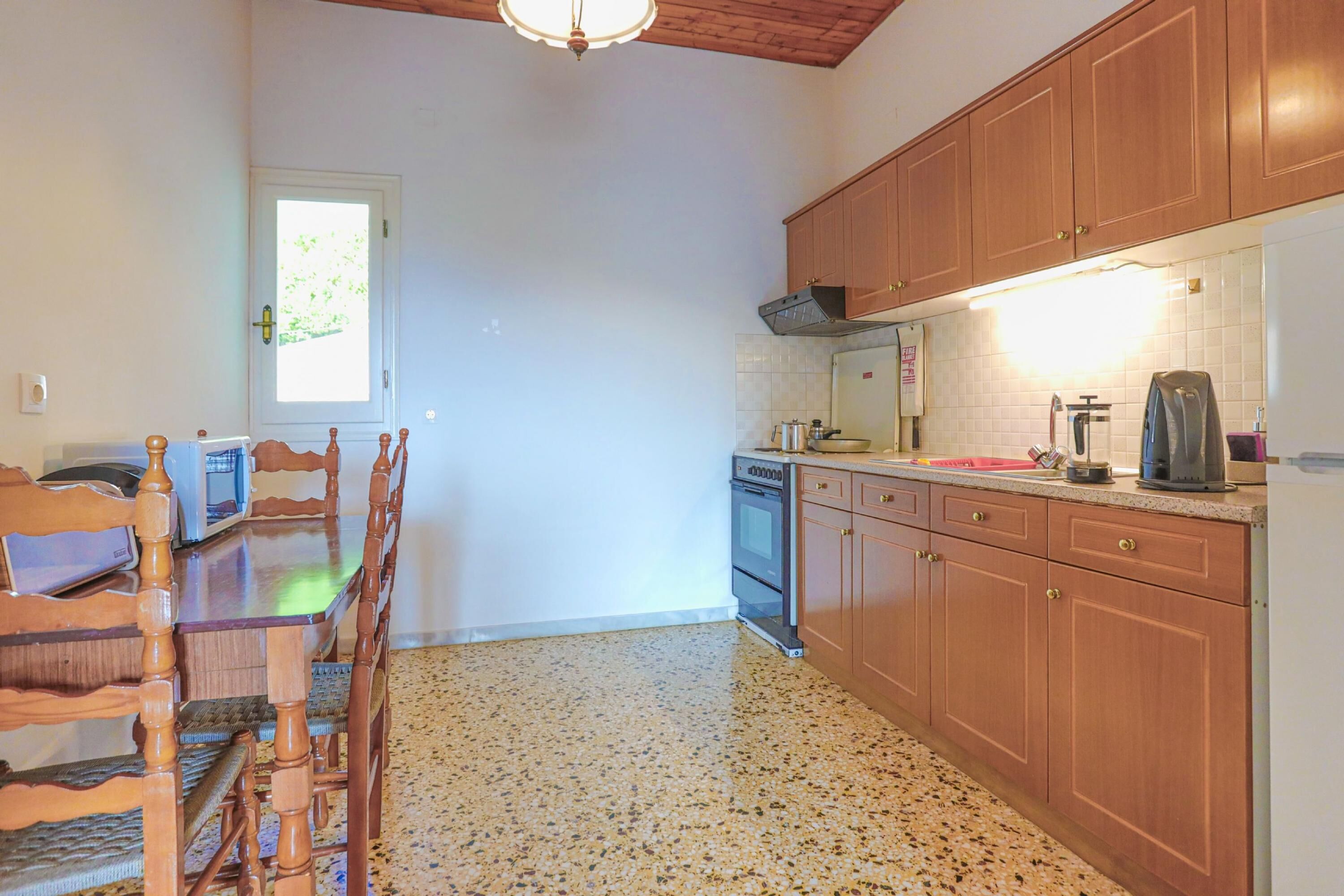 A kitchen with wooden cabinets, a microwave, a stove, and a sink.