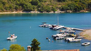 A marina with boats docked, surrounded by greenery and hills. - Anna Apartment Agios Stephanos (Corfu)