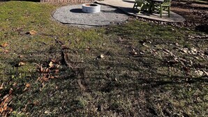 A small building with a porch, a fire pit, and a picnic table in a park setting. - Cabin 3 - Everything you need in this Cabin for a great weekend. (Connellsville)