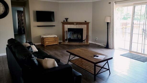 Ein Wohnzimmer mit Kamin, einer Couch, einem Couchtisch und einem Fernseher.