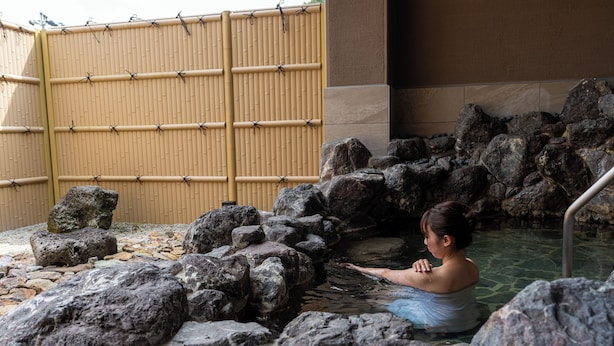 A stone bath surrounded by rocks and a bamboo fence. - Kyou Gohan to Rotenburo no Yado Yunohanatsukiya (Kameoka)