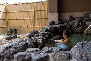 A stone bath surrounded by rocks and a bamboo fence. - Kyou Gohan to Rotenburo no Yado Yunohanatsukiya (Kameoka)