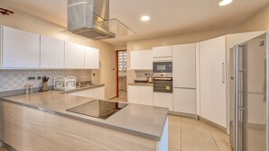 A modern kitchen with white cabinets, a stainless steel refrigerator, and a built-in oven. - Kikambala Modern Apartment with Balcony (Nairobi)