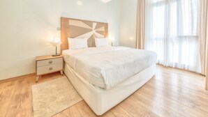 A modern bedroom with a large bed, bedside tables, and a nightstand. - Kikambala Modern Apartment with Balcony (Nairobi)
