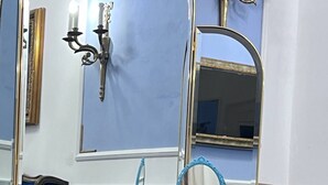 A blue vanity with a mirror and a telephone. - Property Palazzo Caldarulo (Polignano a Mare)