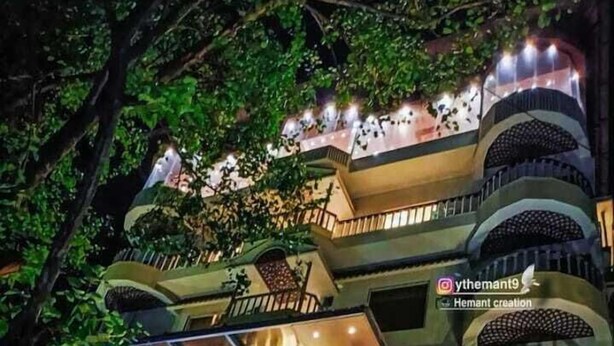 A multi-story building with a modern design, featuring balconies with railings and a large glass facade. - I Towne (Deoghar)