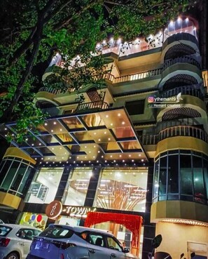 A multi-story building with a modern design, featuring balconies with railings and a large glass facade. - I Towne (Deoghar)