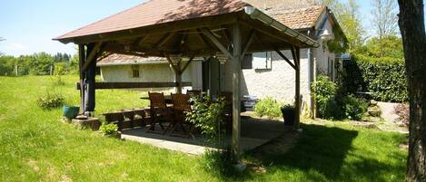 A rustic house with a wooden porch and a stone chimney.