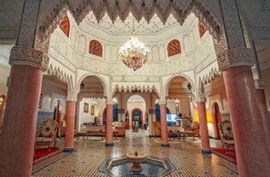 An ornate interior with arches, columns, and a chandelier.
