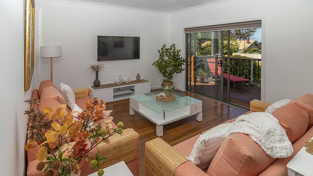 Una sala de estar moderna con sofá, mesa de centro y plantas decorativas.