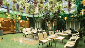 A restaurant with indoor plants, green walls, and a tiled floor. - Pleiku Hotel by Gia Lai Tourist (Pleiku)