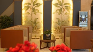 A lobby with seating areas, a central table with a plant, and decorative wall panels. - Pleiku Hotel by Gia Lai Tourist (Pleiku)