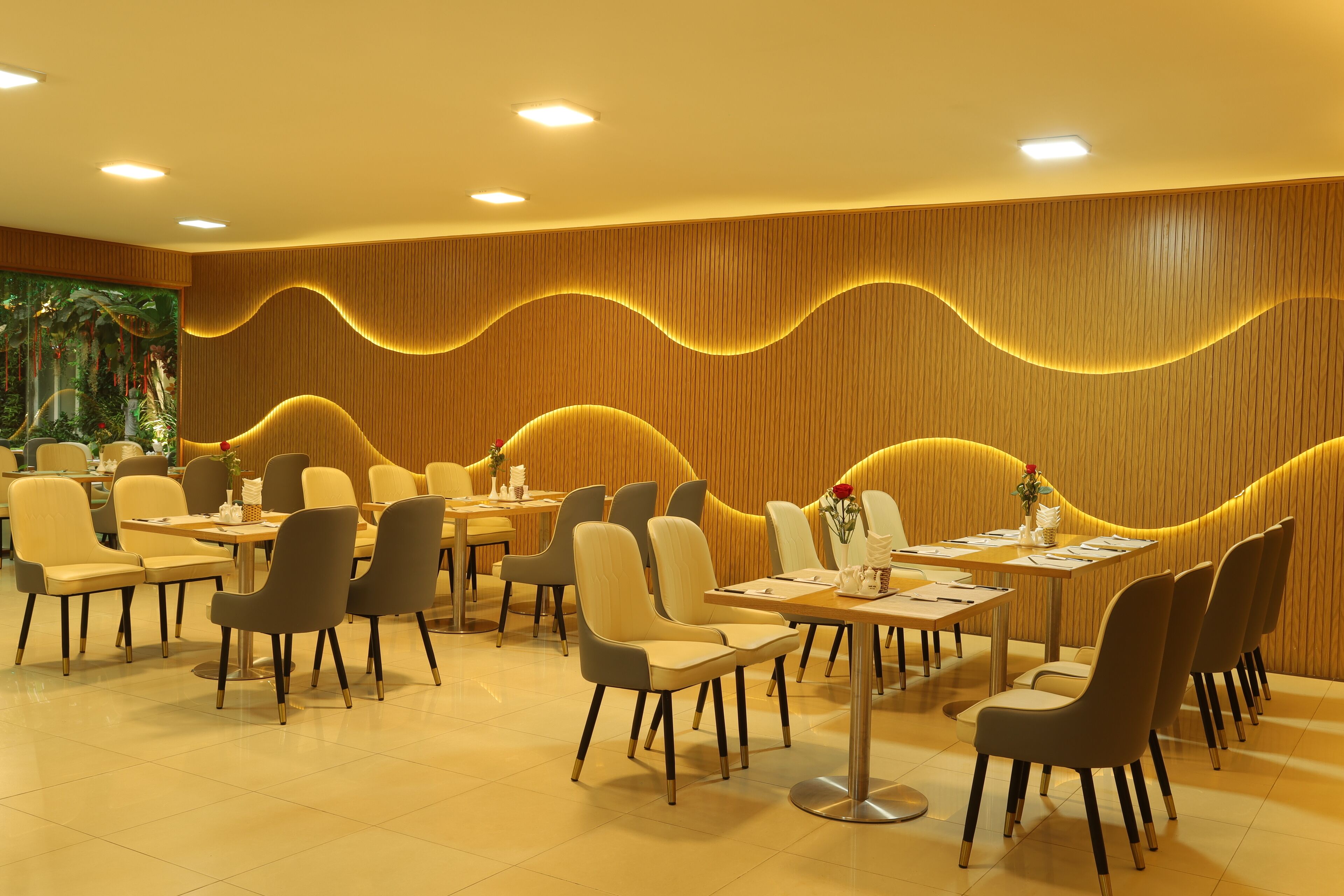 A restaurant with a modern interior, featuring a wave-patterned wall design and a variety of seating arrangements.