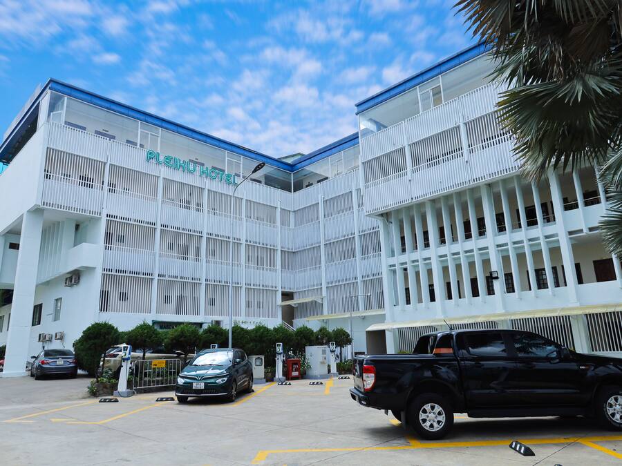A modern hotel with a white facade and balconies.